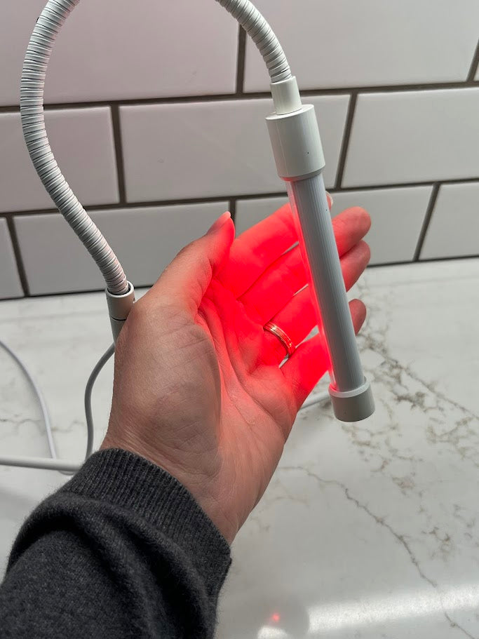 Hand holding a flexible LED light strip with a white background