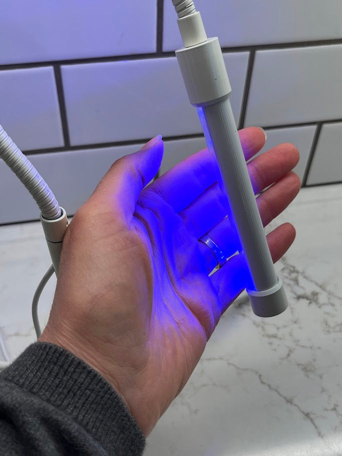 Hand holding a flexible LED light strip with a white background