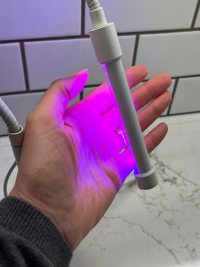 Hand holding a flexible LED light strip with a white background