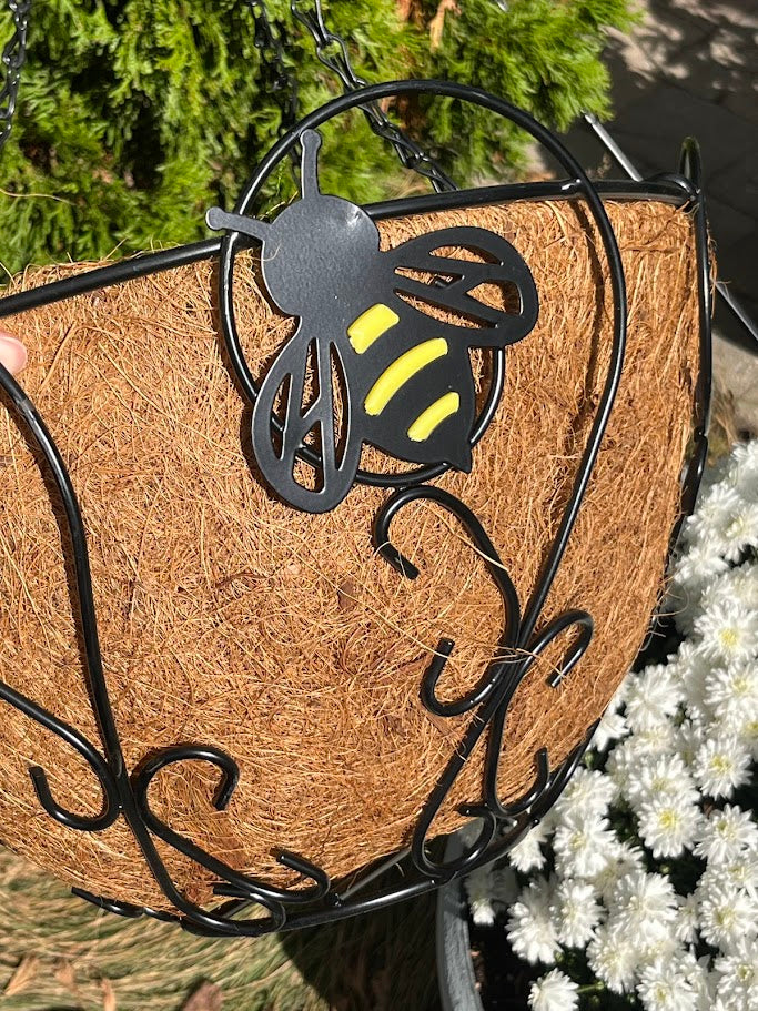 Decorative hanging basket with a metal bee design and natural wood texture.