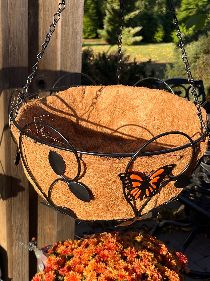 Decorative hanging basket with butterfly design against a wooden background