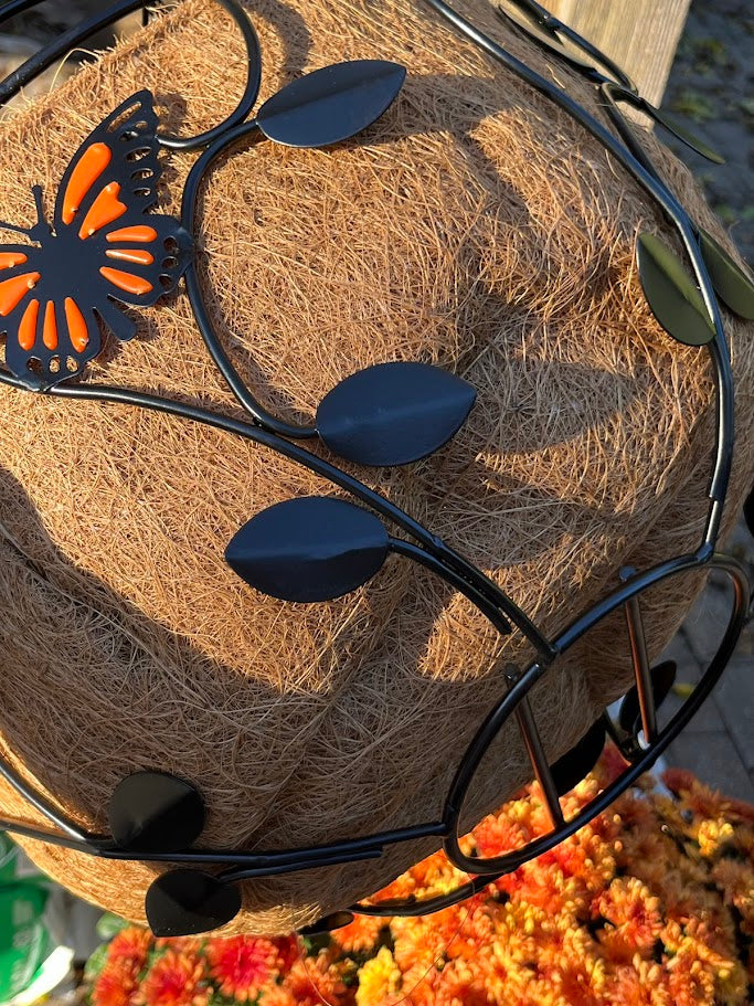 Decorative basket with butterfly and leaf accents on a textured surface.