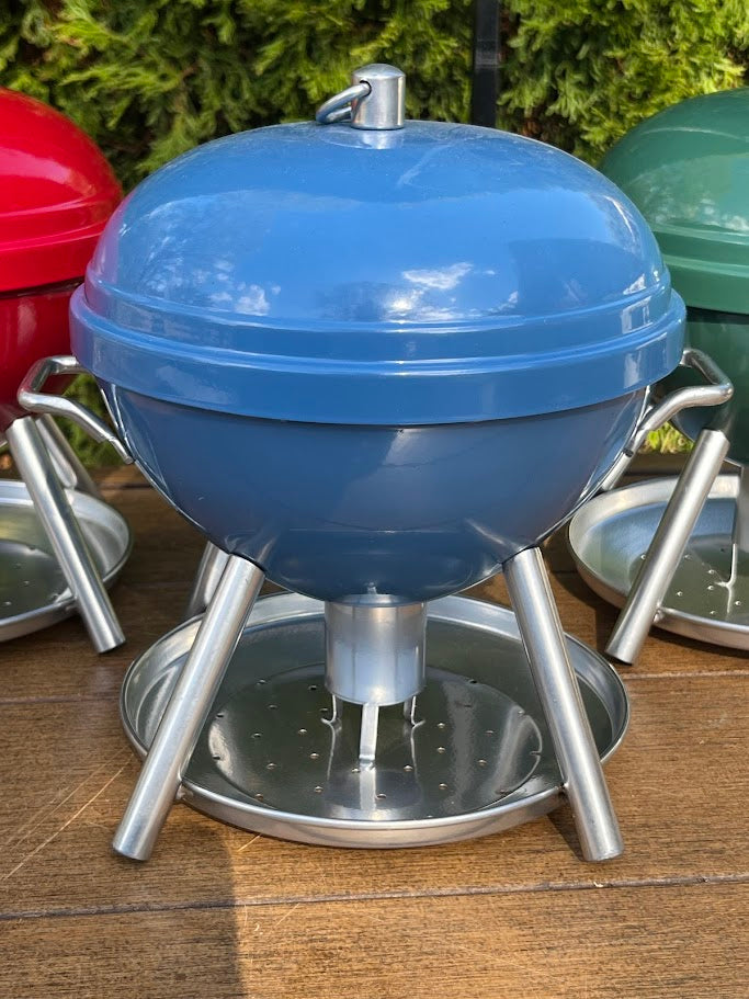 Blue BBQ shaped Birdfeeder against a greenery background