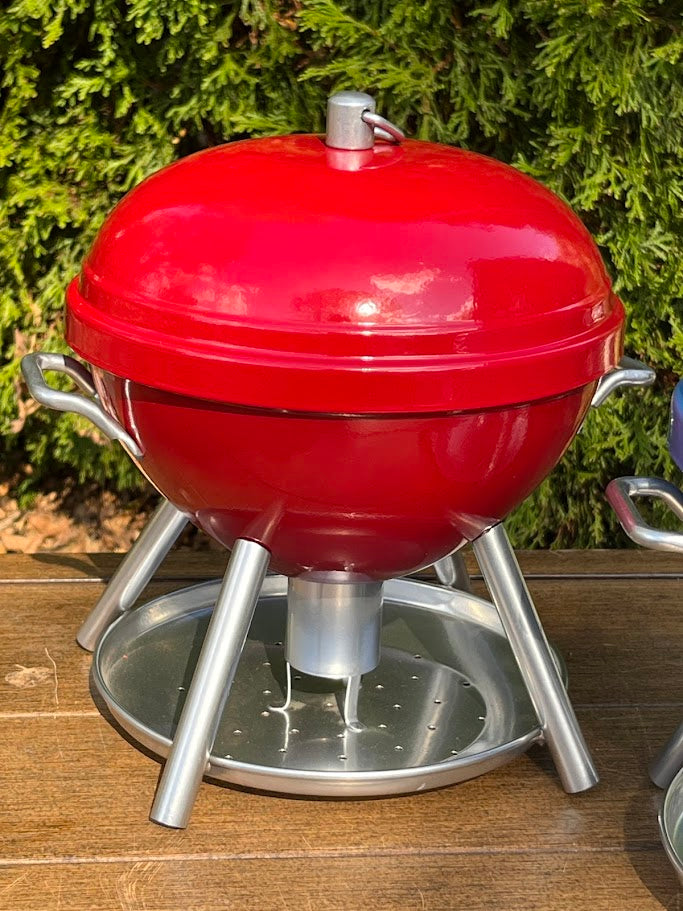 Red BBQ shaped Birdfeeder against a greenery background
