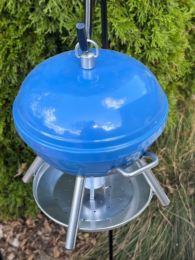 Blue BBQ shaped Birdfeeder against a greenery background