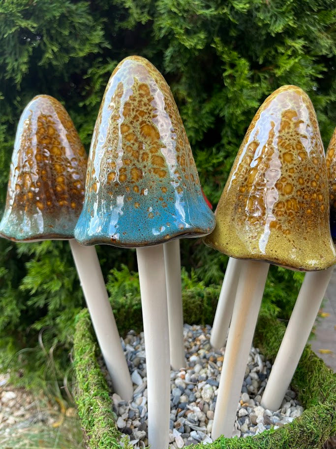 Three ceramic mushrooms with textured tops on a green background