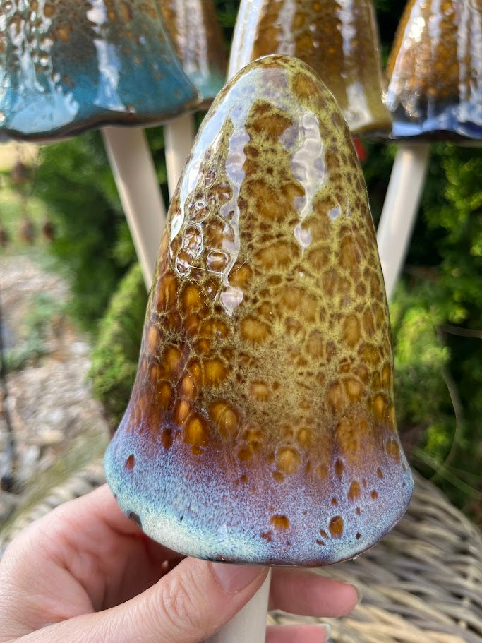 Hand holding a textured ceramic vase with a natural, earthy finish.