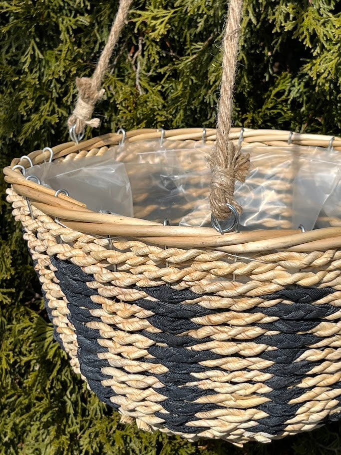Woven basket with a zigzag pattern hanging against a green foliage background
