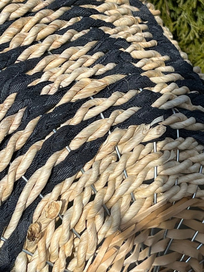Close-up of a woven mat with black and beige pattern