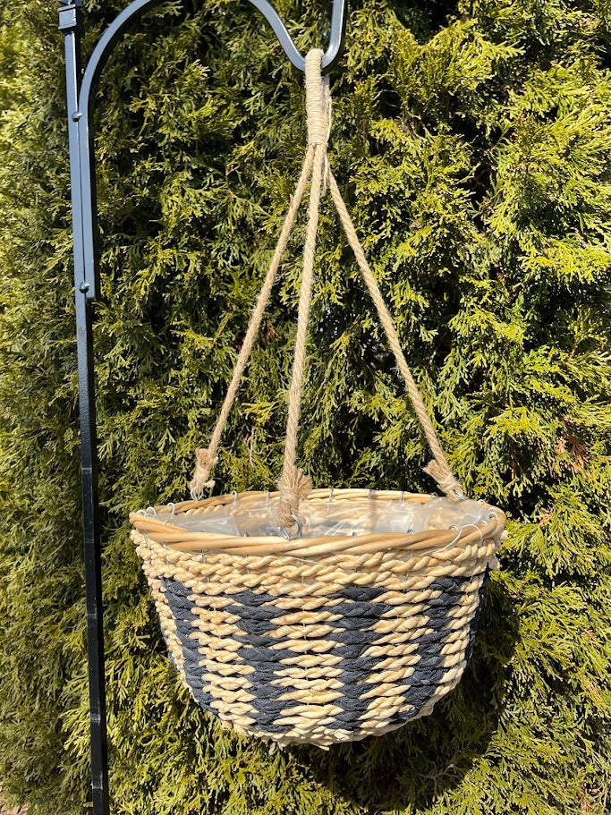 Woven hanging basket with a rope hook against a green foliage background