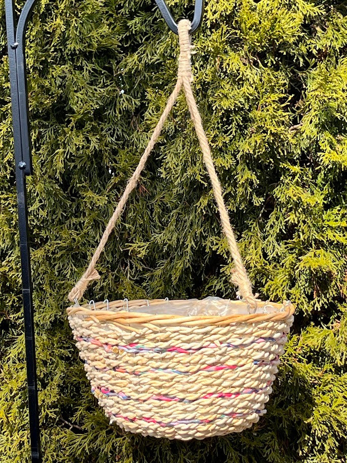 Woven hanging basket with colorful accents against a green foliage background