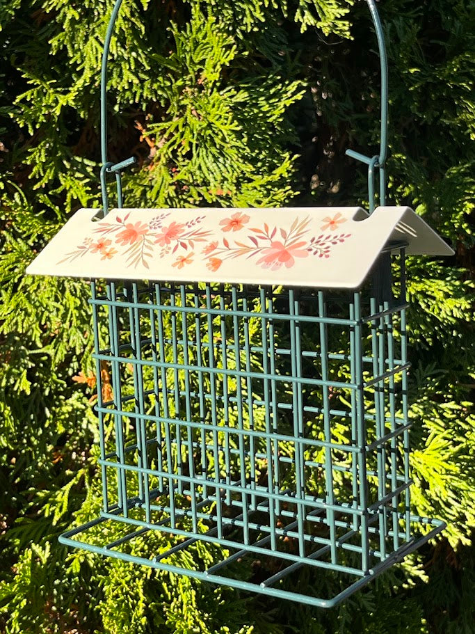 Bird feeder with floral design on a green background