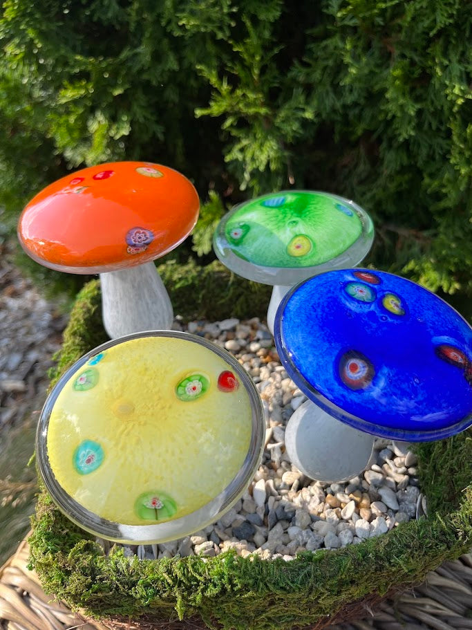 Colorful glass mushroom decorations on a natural background