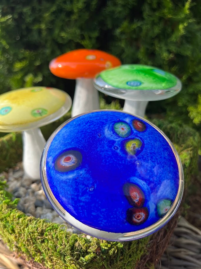 Colorful glass mushroom decorations on a natural background