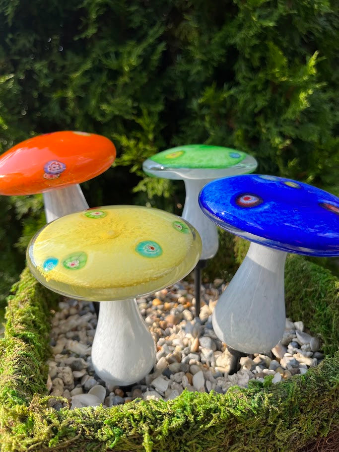 Colorful glass mushrooms on a natural background
