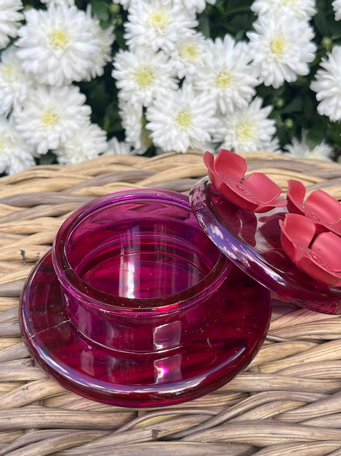Red flower-shaped hummingbird feeder  with white flowers in the background