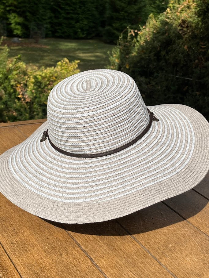 White sun hat on a wooden surface with a blurred natural background
