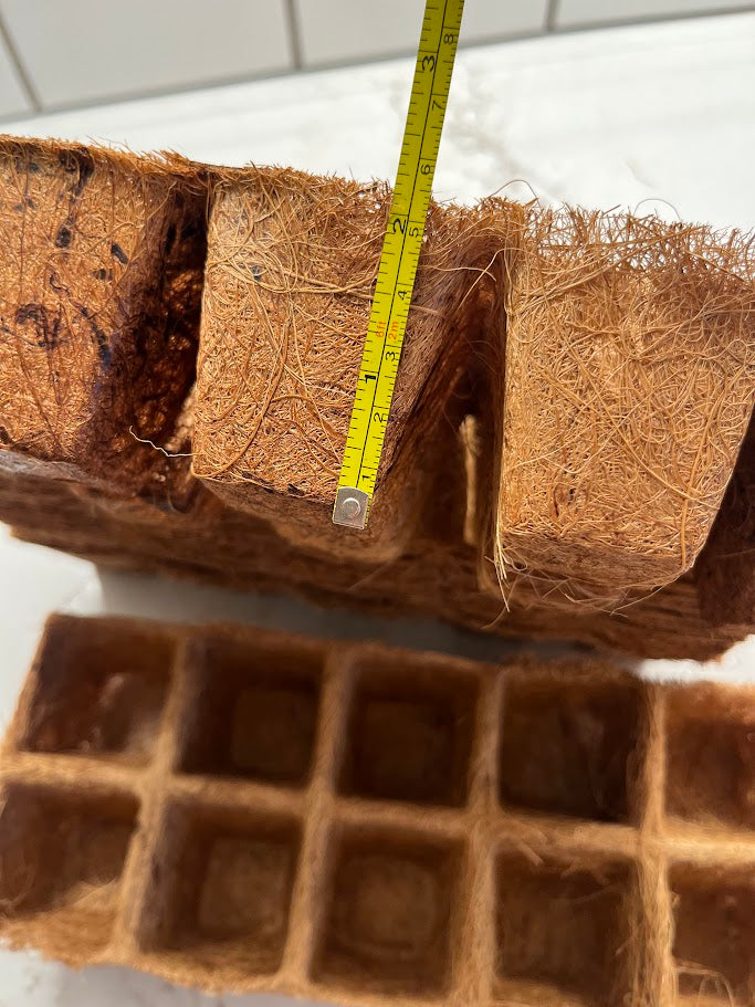 Coconut coir block with a measuring tape and a grid-like material on a white background