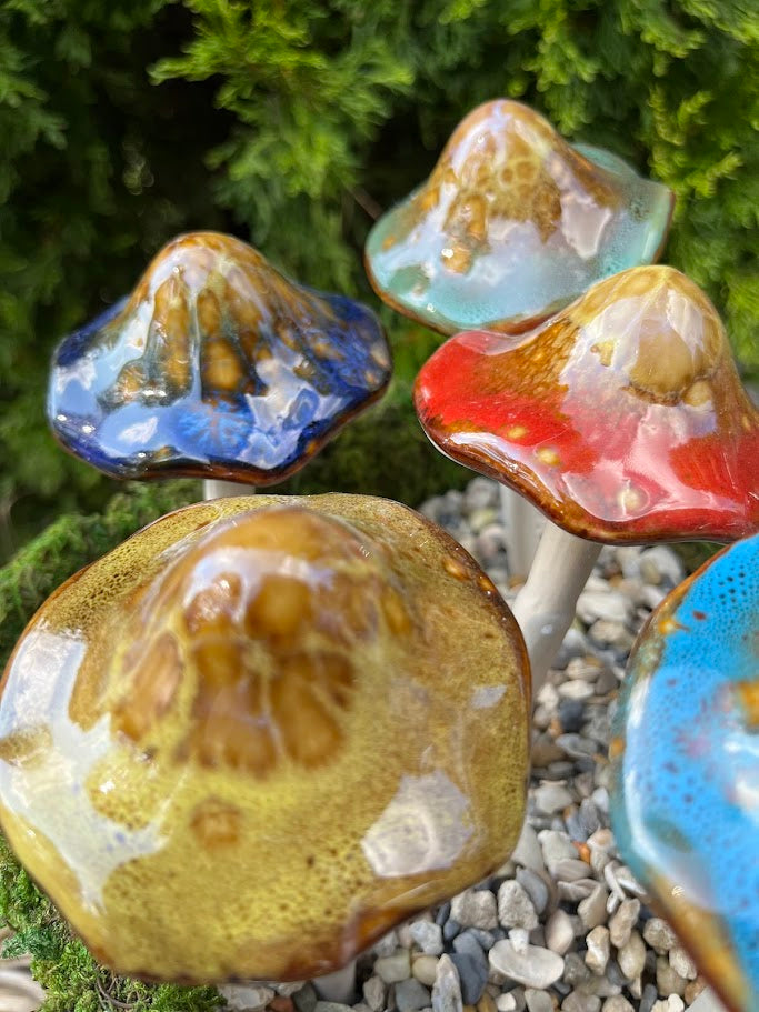 Colorful ceramic mushroom sculptures on a natural background