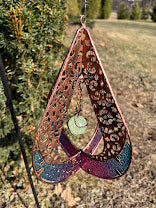 Decorative hanging item with intricate patterns and colors on a natural background
